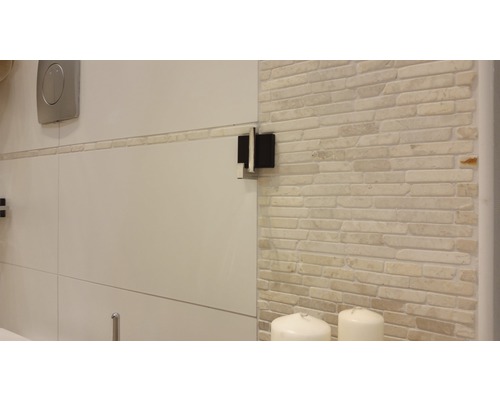 Detailopname van een badkamer met een betegelde muur en sanitair