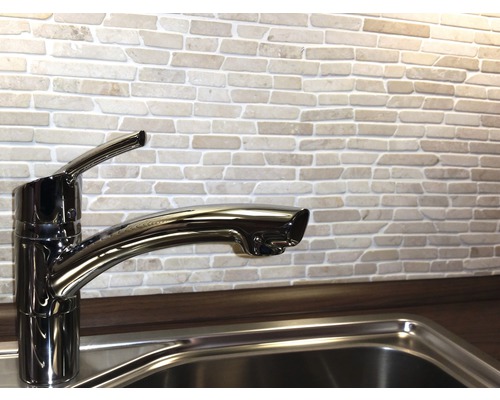 Keuken gootsteen met kraan voor een bakstenen muur