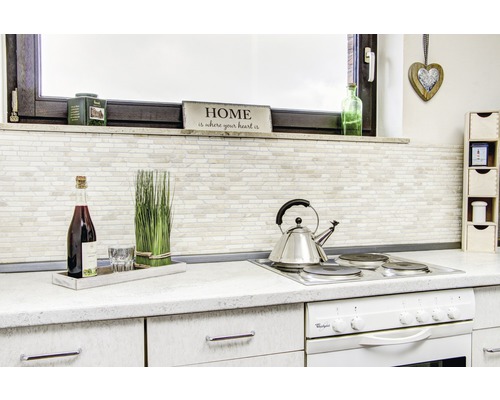 Keukenscène met kookplaat, theepot, decoraties en keukengerei op een aanrecht.