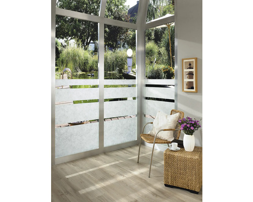 Lichte kamer met raamfolie, stoel en bijzettafel met bloemenvaas