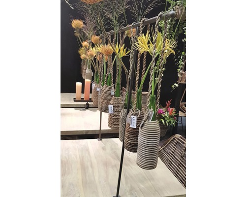 Decoratieve bloemstukken met vazen in gevlochten manden aan een hanger