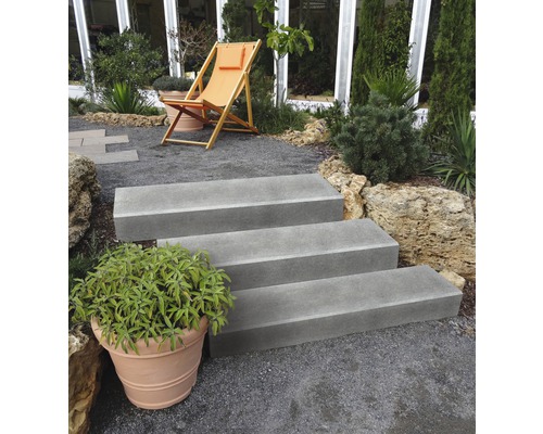 Buitentrap met drie treden in een tuin met grindpad en ligstoel