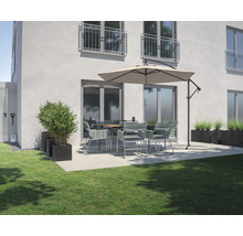 Tuinscene met eettafel, stoelen, parasol en plantenbakken op een terras