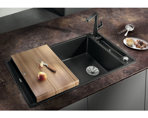 Spoelbak van composiet met snijplank en kraan op een aanrecht