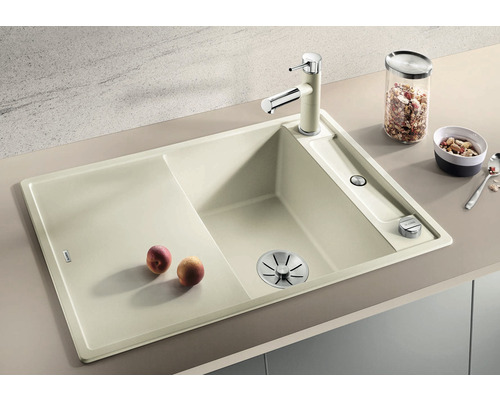 Beige aanrechtspoelbak met afdruiprek, kraan en afvoer