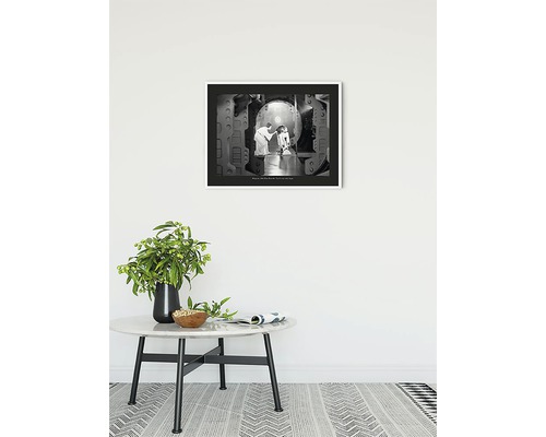 Ingelijste zwart-witfoto met scène uit Star Wars aan een muur boven een tafel