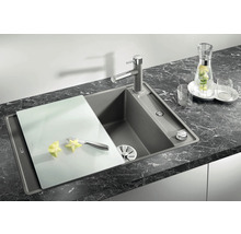 Spoelbak met snijplank en kraan op een donker aanrechtblad