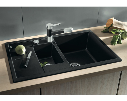 Zwarte spoelbak met twee bakken, kraan en afdruiprek op een werkblad