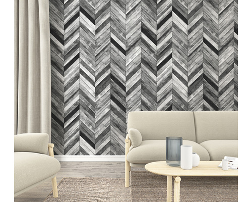 Woonkamer met visgraatbehang in houtlook, bank en tapijt