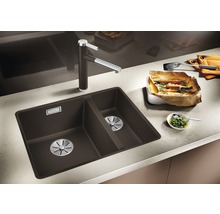 Keukenscène met spoelbak, kraan en bereide gerechten op het aanrecht.