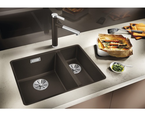 Keukenscène met spoelbak, kraan en bereide gerechten op het aanrecht.