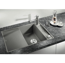 Granieten spoelbak met afdruiprek en kraan op een werkblad.