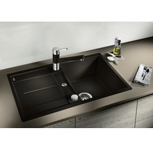 Donkere gootsteen met afdruiprek en kraan op een aanrecht.