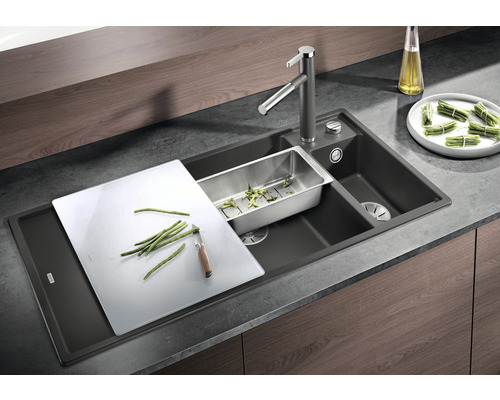 Spoelbak met kraan, snijplank en afdruipbak voor het werk in de keuken.