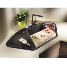 Hoekspoelbak met kraan, snijplank, kruiden en tomaten op het aanrecht.