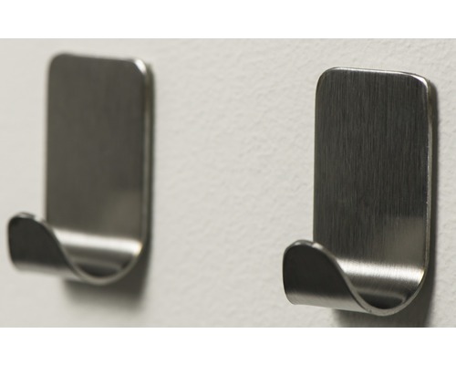 Twee zelfklevende metalen kledinghaken aan een muur
