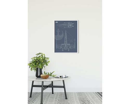 Ingekadreerde blauwdruk van een ruimteschip aan de muur boven een bijzettafel.