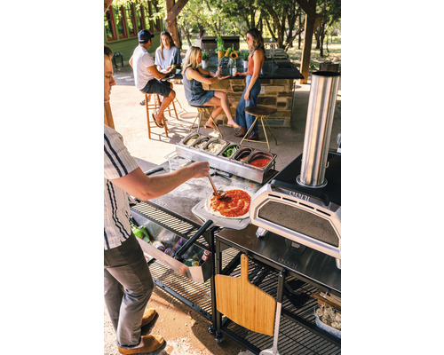 Scene met pizzaoven, ingrediënten en mensen buiten die pizza maken