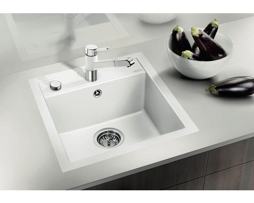Keuken spoelbak met kraan en afvoerfilter naast een schaal met aubergines