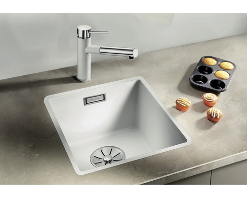 Spoelbak met mengkraan en muffins op een aanrecht