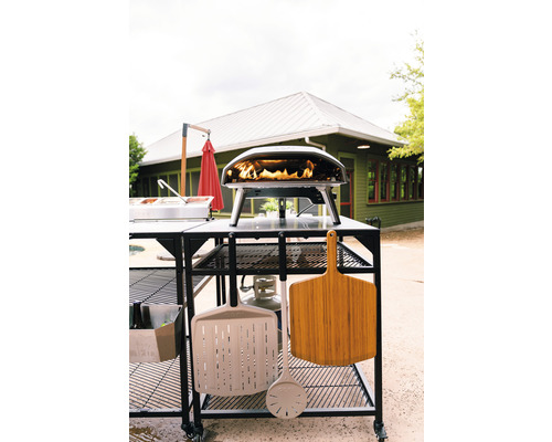 Pizzaoven met accessoires op een verrijdbare tafel in de buitenlucht