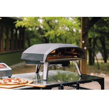Ooni pizzaoven met pizza op een houten plank
