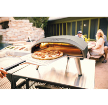 Ooni pizzaoven met pizza op pizzaschep buitenshuis