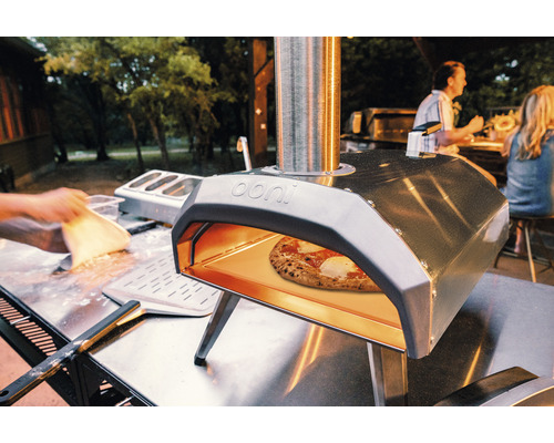 Ooni pizzaoven met pizza in de tuin