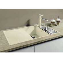 Beige aanrechtspoelbak met afdruiprek, spoelbak en bijpassende kraan.