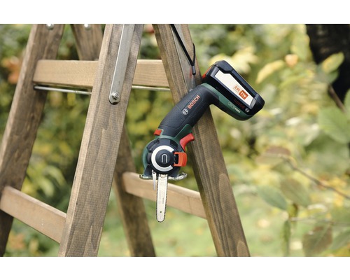 Accukettingzaag aan een houten ladder