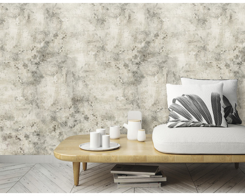 Woonkamer met bank, tafel, servies en beige behang met steenlook