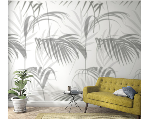 Woonkamer met palmboom behang, bank en kamerplant