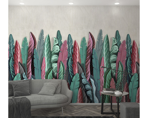 Woonkamer met groot bladerenwandkleed, bank en bijzettafel.