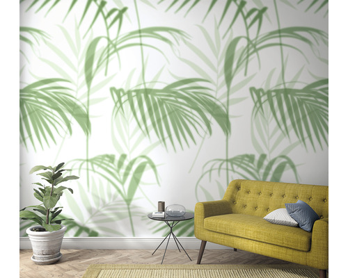 Woonkamer met palmenmotief behang, bank, plant en bijzettafel