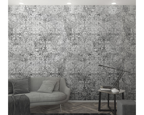 Woonkamer met behang met motief, bank en bijzettafel met lamp.