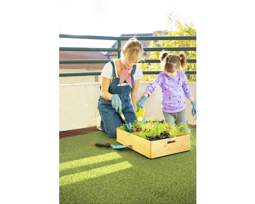 Moeder en dochter tuinieren samen in een verhoogde plantenbak op een balkon