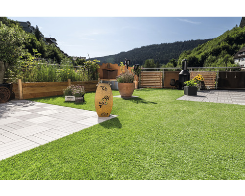 Tuin met gazon, plantenbakken, decoratieve elementen en barbecue