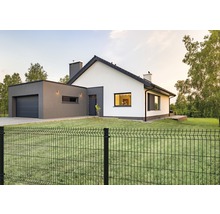 Een modern huis met een metalen hek in de tuin.