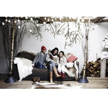Gezellige winterdecoratie met familie op de bank, berkenstammen en decoratie