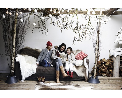Gezellige winterdecoratie met familie op de bank, berkenstammen en decoratie