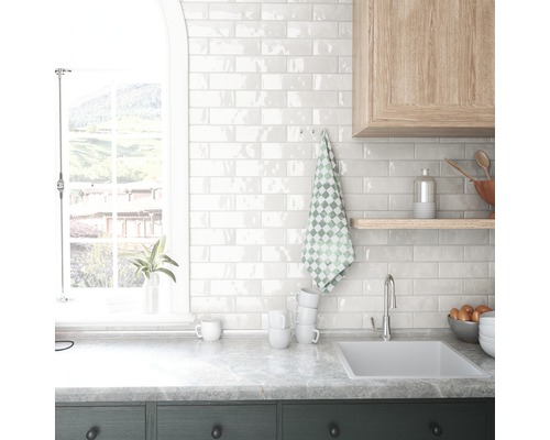 Keukenscène met gootsteen, betegelde muur en raam