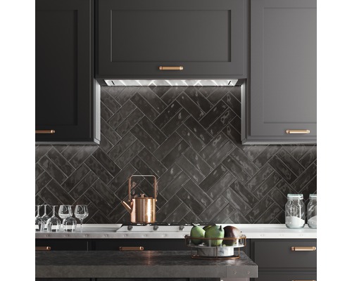 Keukenscène met donkere kasten, visgraattegels en keukengerei