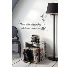 Woonkamer met twee bijzettafels, een staande lamp, een stoel en een muursticker