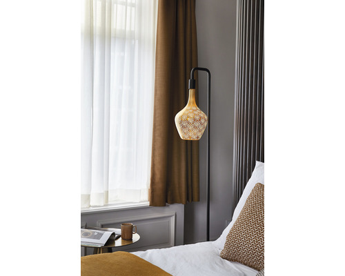 Slaapkamer met vloerlamp, bed en gordijnen