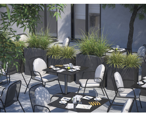 Buitenruimte met tafels, stoelen en plantenbakken