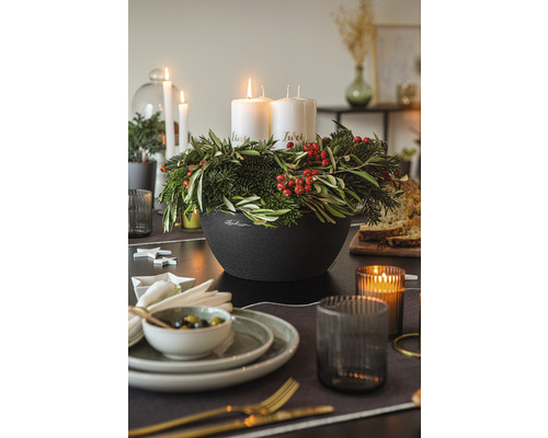 Feestelijke tafel met adventskrans, kaarsen, servies en decoratie voor een sfeervolle kerstperiode.