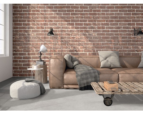 Woonkamer met leren bank, bakstenen muur en houten tafel