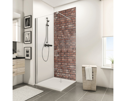 Badkamer met douchecabine, douchebak, douchearmatuur en bakstenen muur