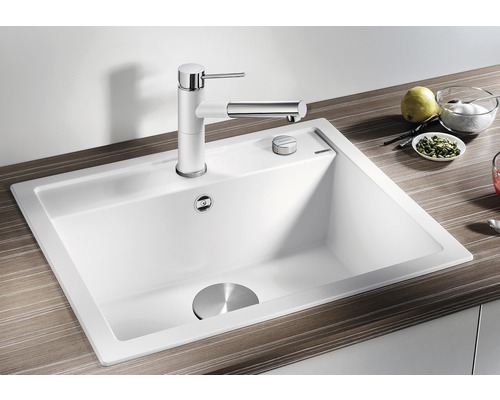 Witte gootsteen met kraan en afvoergarnituur op een werkblad