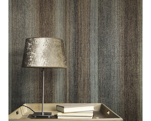 Close-up van een muur met een behang met streepmotief, een tafel met een lamp en boeken